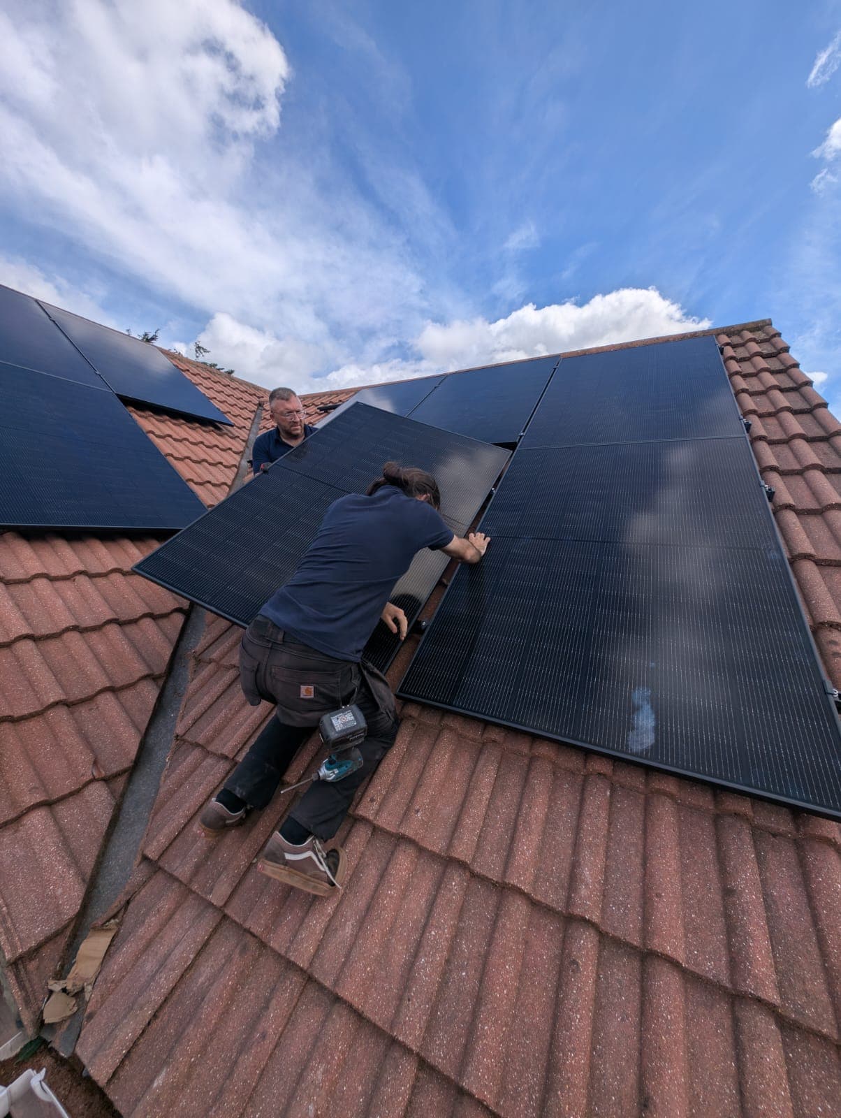 New Gen team members installing solar panels on a roof