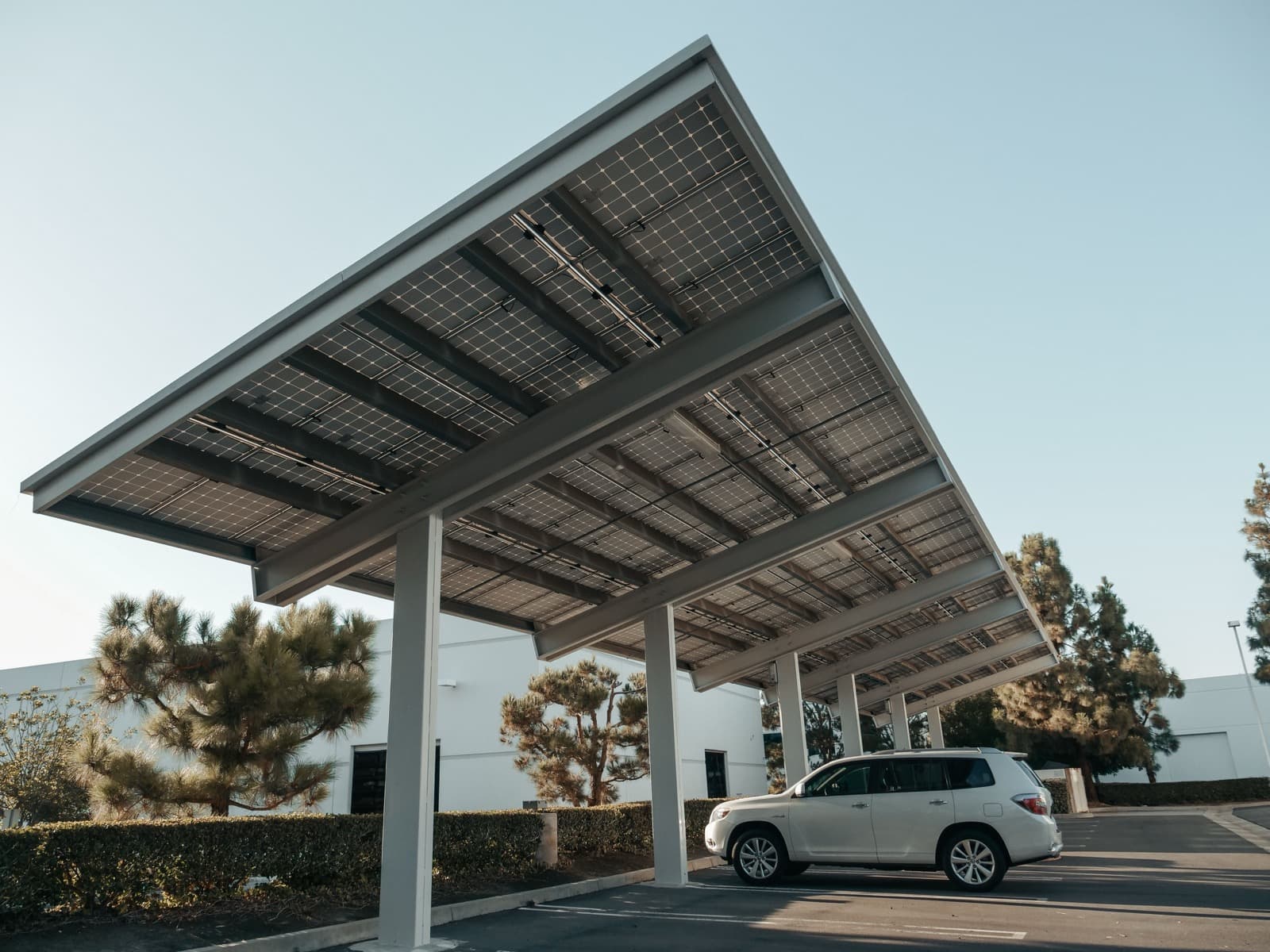 A steel-framed solar carport canopy, single car parked beneath