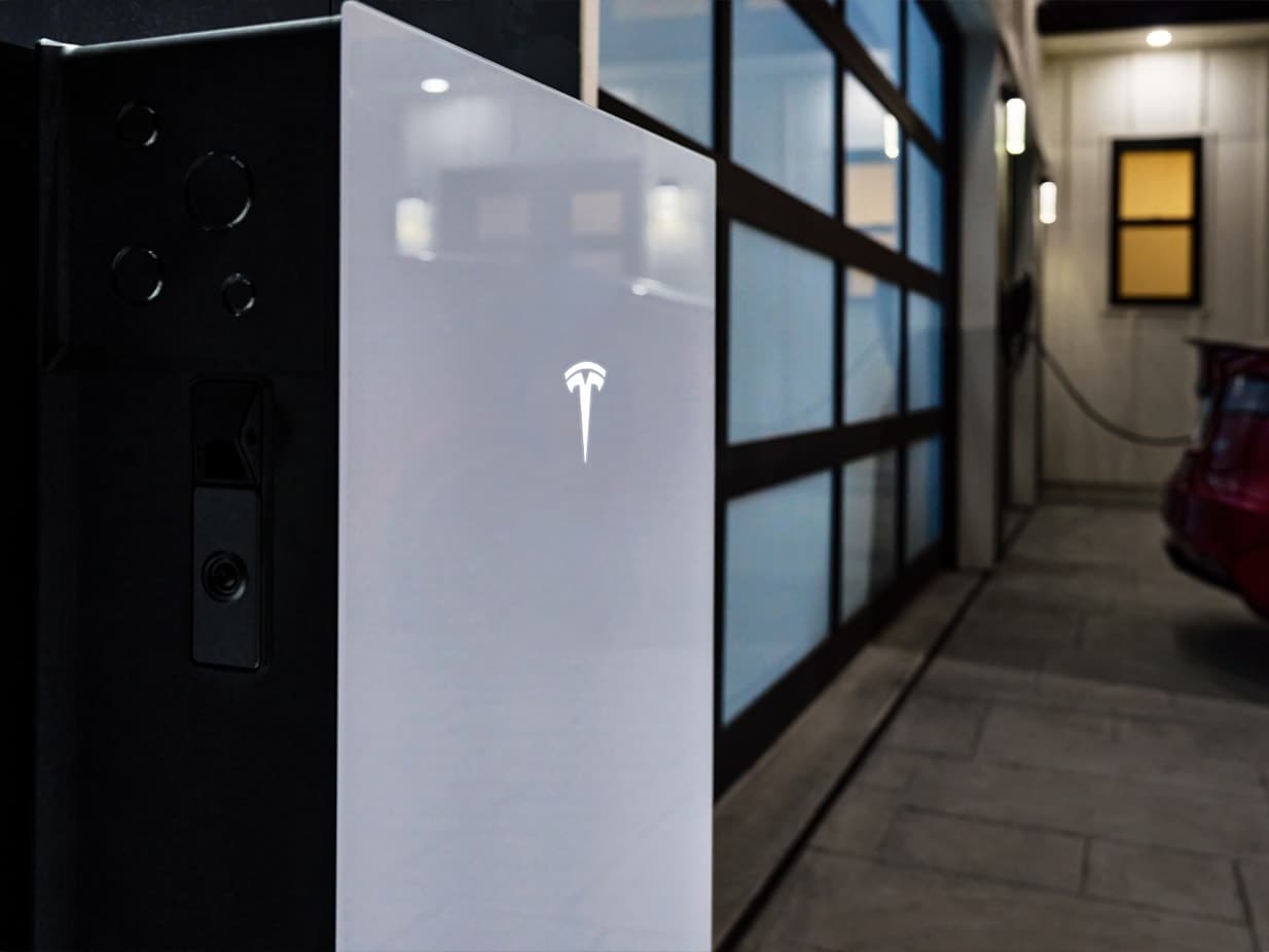 A Tesla Powerwall 3 wall-mounted outside a home, close detail